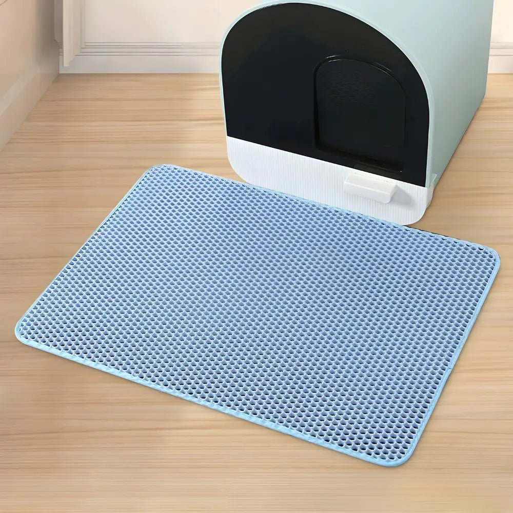 Tapis litière chat PurraMat bleu avec cellules profondes devant un bac à litière
