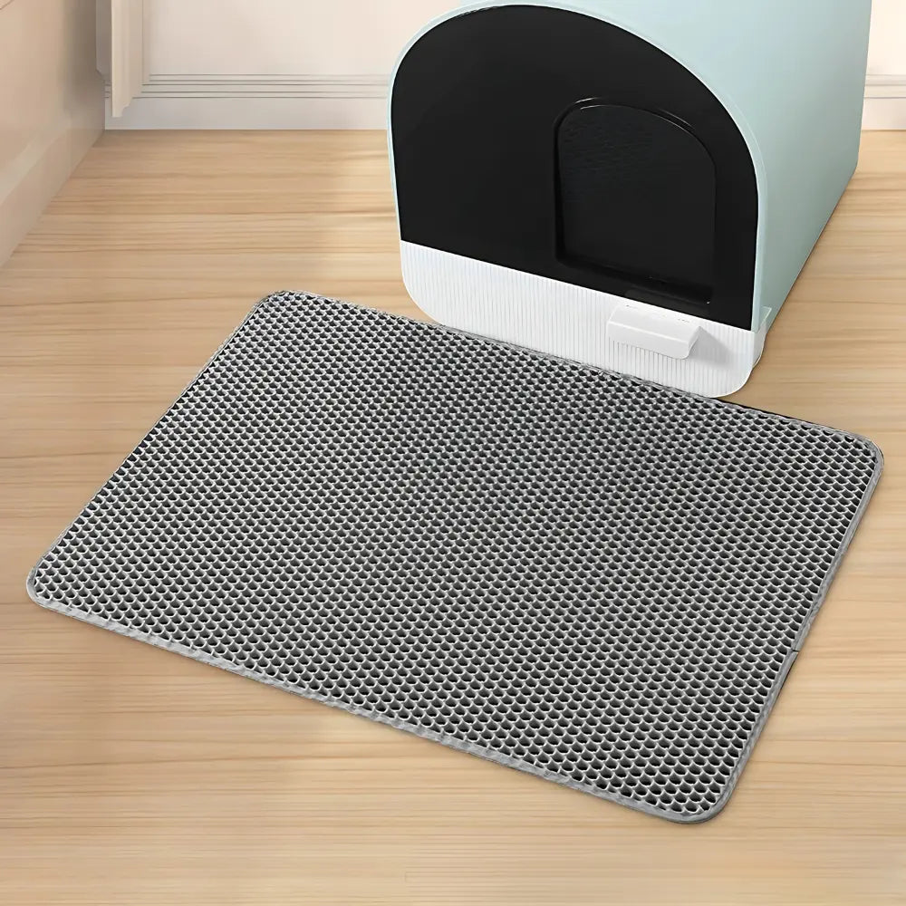 Tapis litière chat PurraMat gris avec structure anti-grains devant un bac couvert