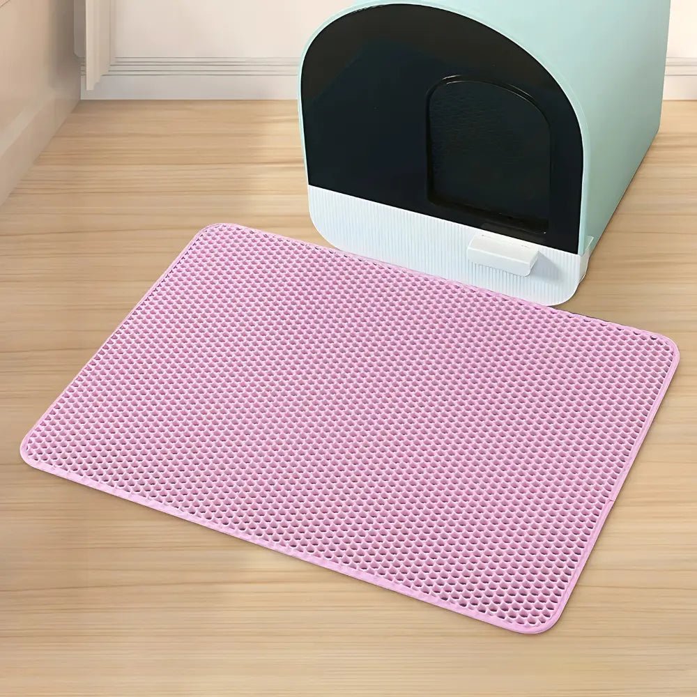 Tapis litière chat PurraMat rose devant un bac à litière couvert
